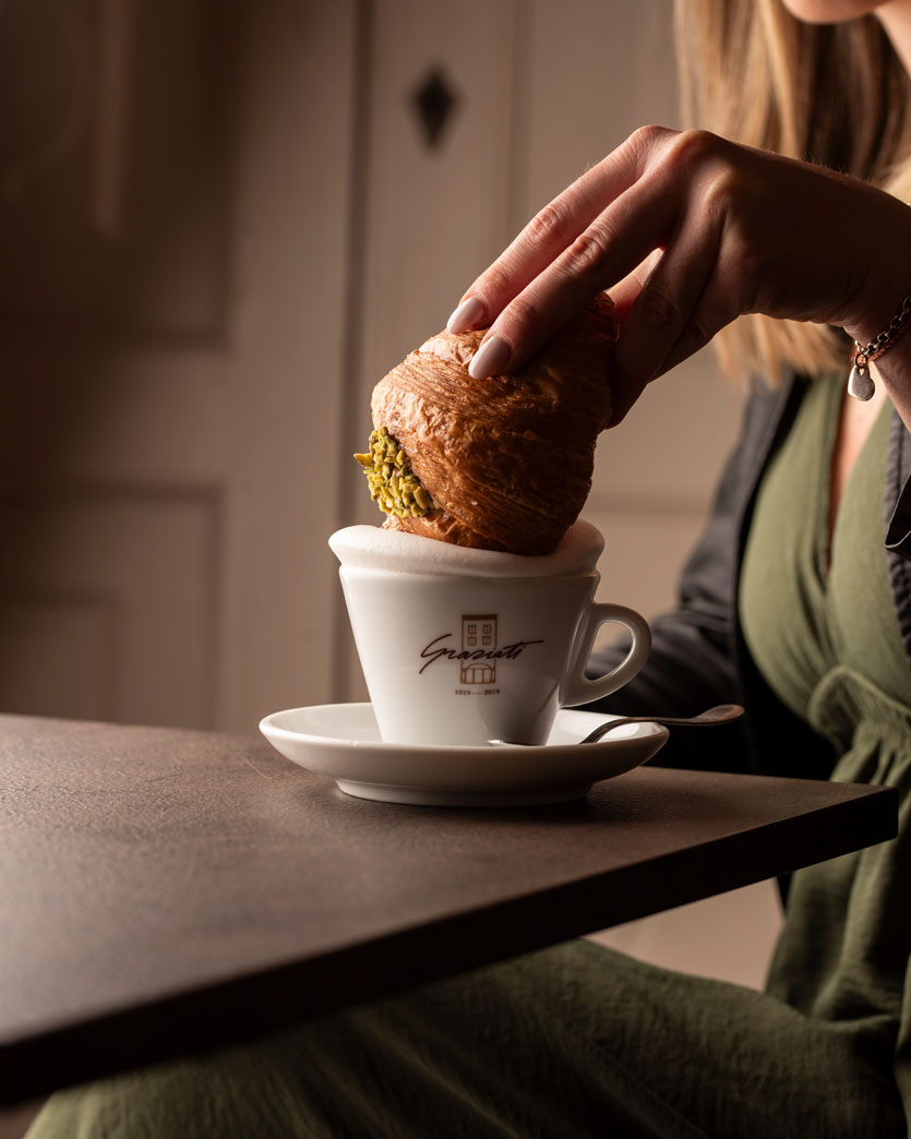 Croissant al pistacchio artigianale intinto nel cappuccino alla Pasticceria Graziati nel centro di Padova